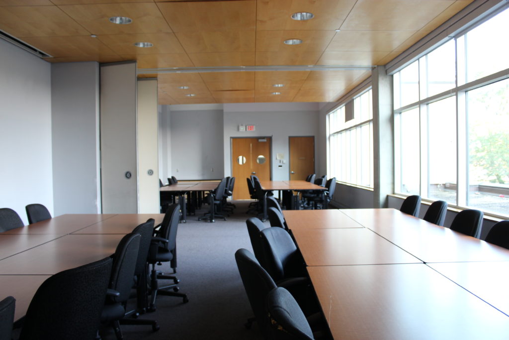 Image of a MUSC meeting room with 4 groupings of tables, each with 12 chairs around
